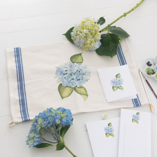 Watercolor hydrangea tea towel with blue floral design and vintage stripe, offering a timeless New England coastal style for the kitchen.