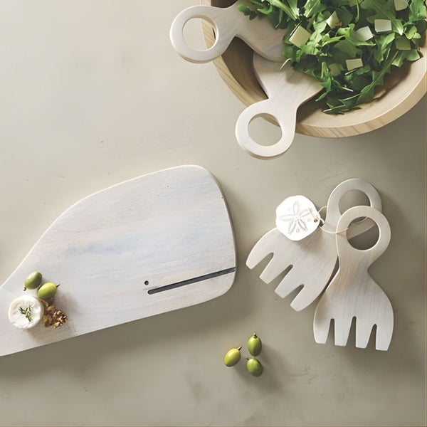 Wood claw salad servers with light natural finish and sand dollar gift tag styled on table next to wood whale board and salad bowl.
