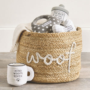 Hair of the Dog plush dog toy displayed with other pet toys in a basket