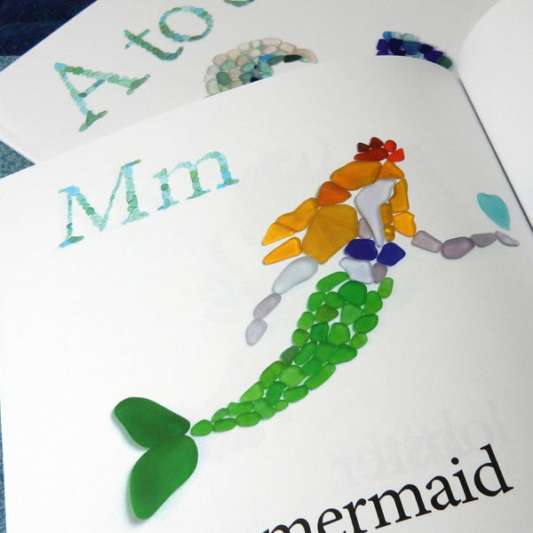 A To Sea Sea Glass Alphabet Book Open To Mermaid Page, Colorful Beach Glass Art And Coastal Children’s Book