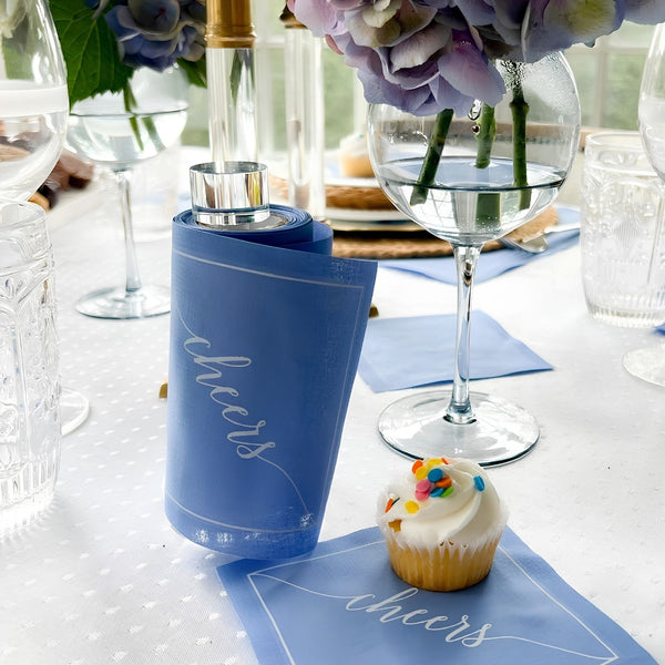 Clear Glass Cocktail Napkin Stand With Blue Napkins On A Table Setting For Entertaining