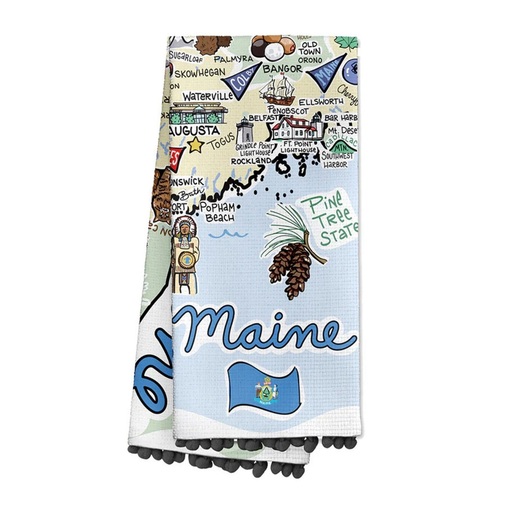Folded Maine Cotton Tea Towel Featuring Maine Map Artwork With Coastal Landmarks Pine Tree State Design And Black Pom Trim