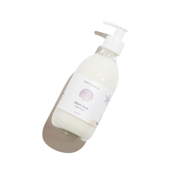 Warm Sand Body Lotion in a glass bottle, enriched with avocado oil and oat extract., 10 oz
